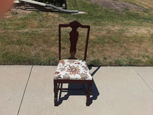 wood upholstered chair repaired in a driveway