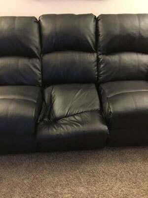 black leather couch that needs to be repaired